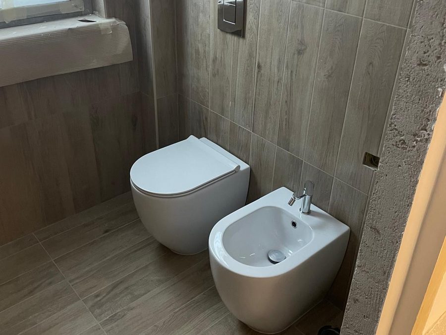 Vaso e bidet a filo muro in un bagno rifatto